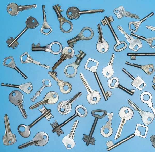 Ключи установлены на синем фоне. Ключи от замков и сейфы для безопасности собственности и защиты дома. Различные антикварные и новые типы ключей . — стоковое фото
