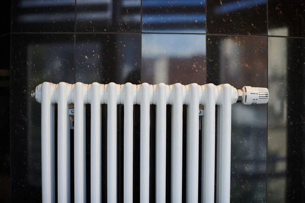 Radiador de aquecimento no escritório, de perto. Trocadores de calor brancos. Ferro radiador de vapor de alumínio. Padrão de tubulação . — Fotografia de Stock
