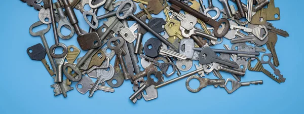 Llaves colocadas sobre fondo azul. Cerradura de puerta llaves y cajas fuertes para la seguridad de la propiedad y la protección de la casa. Diferentes tipos antiguos y nuevos de llaves . —  Fotos de Stock