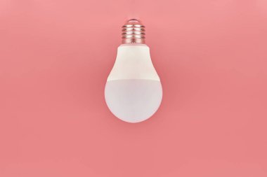 Enerji tasarrufu ampulü, kopyalama alanı, pembe zemin. Asgari fikir kavramı.