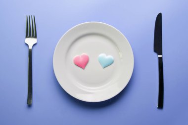 İki kalp ve çatal bıçak takımı. Restoran konseptinde romantik bir akşam yemeği. Düğün resepsiyonunda aşıkların buluşması.