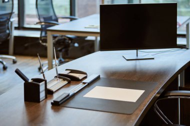 Modern ofis işyeri. Çalışan masasında monitör var. Şefin ya da patronun iş yeri.