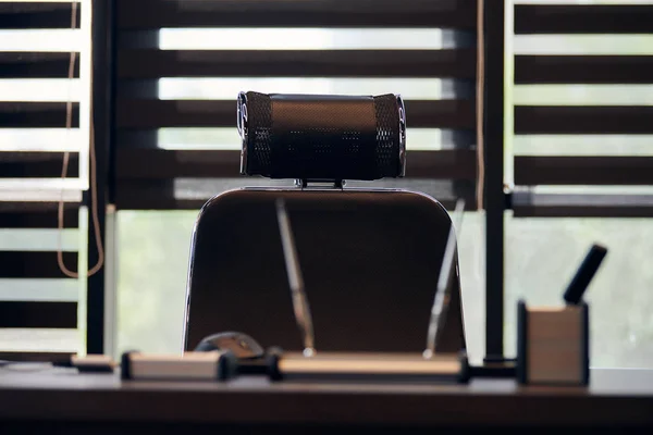 Business office workplace. Work place for chief, boss or other employees. Table and comfortable chair. Light through the half open blinds