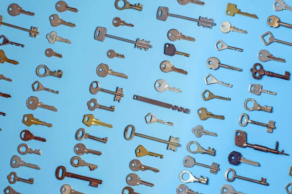 Τα κλειδιά είναι σε μπλε φόντο. Κλειδιά κλειδαριάς πόρτας και χρηματοκιβώτια για ασφάλεια ακινήτων και προστασία σπιτιού. Διαφορετικοί αντίκες και νέοι τύποι κλειδιών. — Φωτογραφία Αρχείου