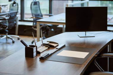 Modern ofis işyeri. Çalışan masasında monitör var. Şefin ya da patronun iş yeri.