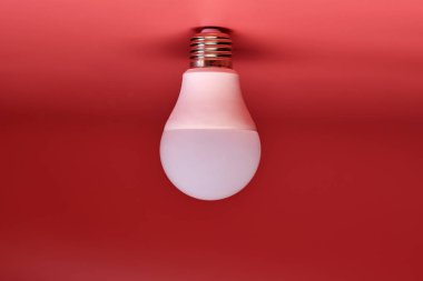 Enerji tasarrufu ampulü, kopyalama alanı, pembe zemin. Asgari fikir kavramı.