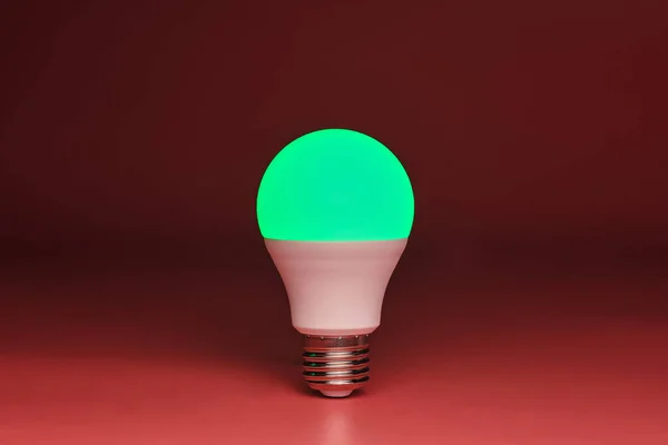 Energy saving light bulb, green light glowing, copy space. Minimal idea concept.