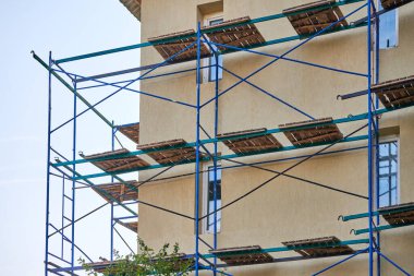 İnşaat alanındaki iskele. İskeleli eksik bina ve dekorasyon. Yeni apartman bloğunda çalışma devam ediyor