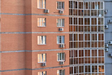 Yeni modern daireleri olan çok katlı bir bina. Çok katlı bir cephe, bir apartman bloğu. Yükseltilmiş bir binada daire kiralamak
