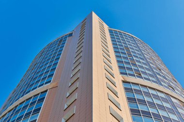 Çok katlı bina cephesi, kopyalama alanı. Fotoğrafçılıkta ritim. Yeni çok katlı cephe, pencereler ve apartman blokları, kapatın. Yüksek binadaki modern daireler. Bakış açısı.