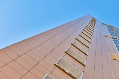 Çok katlı bina cephesi, kopyalama alanı. Fotoğrafçılıkta ritim. Yeni çok katlı cephe, pencereler ve apartman blokları, kapatın. Yüksek binadaki modern daireler. Bakış açısı.