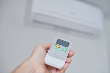 Klima uzaktan kumandası. Oda kremi uzaktan kumandalı el. Boşluğu soğutmak için hava sıcaklığı anahtarı.