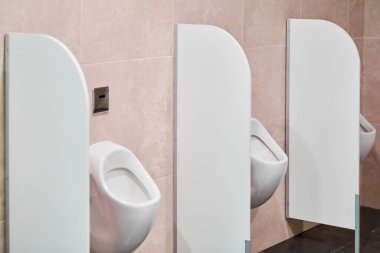 Umumi tuvaletteki pisuvar. Gizlilik bariyerleri ve alışveriş merkezinde sifon kontrol sensörü olan bir sidik. Tuvalet odası..