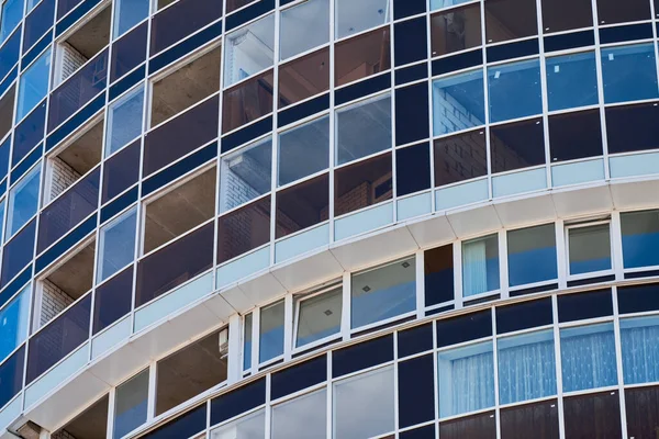 Multistorey building. Rhythm in photography. Multi-storey facade, windows and block of flats, close up. Modern apartments in high raised building. Angle perspective.