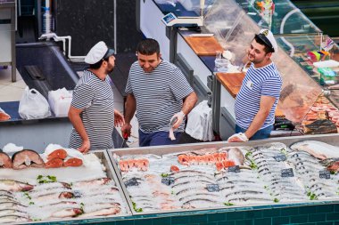 Voronezh, Rusya, 23.08.2019 - Yerel pazarda balık satıcıları. Üç adam balık ticaretini tartışıyor. Markette yeni yakalanmış çeşitli deniz ürünleri..