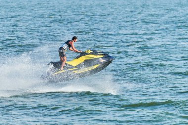 Voronezh, Rusya - 23.08.2019 - Su motosikletli adam. Yaz tatilinde tropikal denizlerdeki şahsi su araçlarında. Genç adam deniz yolculuğu hobisi. PWC spor etkinliği
