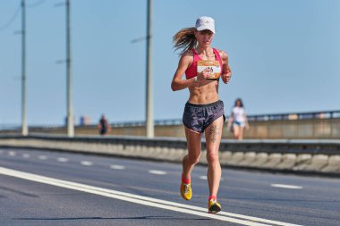 Voronezh, Rusya - 24.08.2019 - Genç kız yol boyunca koşar. Koşu maratonu ve şampiyonluk yarışması, fotokopi alanı. Sokak dışarı koşuyor. Sağlıklı spor etkinliği.