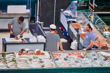 Voronezh, Rusya, 23.08.2019 - Yerel pazarda balık satıcıları. Üç adam balık ticaretini tartışıyor. Markette yeni yakalanmış çeşitli deniz ürünleri..