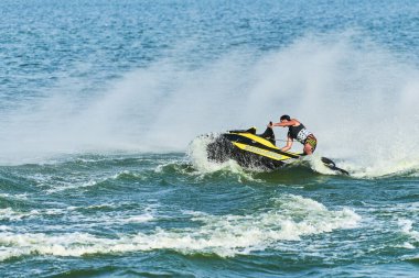 Voronezh, Rusya - 23.08.2019 - Su motosikletli adam. Yaz tatilinde tropikal denizlerdeki şahsi su araçlarında. Genç adam deniz yolculuğu hobisi. PWC spor etkinliği