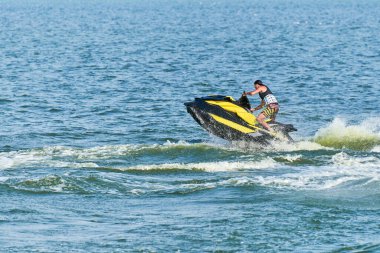 Su motosikletli adam. Yaz tatilinde tropikal denizlerdeki şahsi su araçlarında. Genç adam deniz yolculuğu hobisi. PWC spor etkinliği
