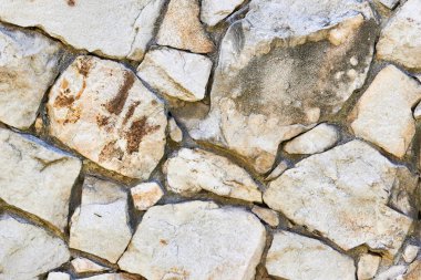 Masonlu kaya duvar dokusu. Eski şatonun temelindeki taşlar. Tasarım veya illüstrasyon için taş duvar arkaplanı
