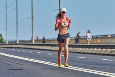 Voronezh, Rusya - 24.08.2019 - Genç kız yol boyunca koşar. Koşu maratonu ve şampiyonluk yarışması, fotokopi alanı. Sokak dışarı koşuyor. Sağlıklı spor etkinliği.