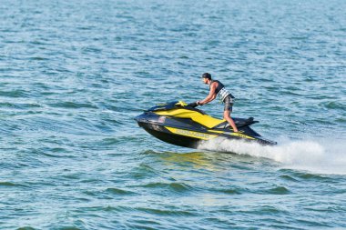 Voronezh, Rusya - 23.08.2019 - Su motosikletli adam. Yaz tatilinde tropikal denizlerdeki şahsi su araçlarında. Genç adam deniz yolculuğu hobisi. PWC spor etkinliği