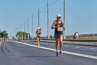 Voronezh, Rusya - 24.08.2019 - Genç kız yol boyunca koşar. Koşu maratonu ve şampiyonluk yarışması, fotokopi alanı. Sokak dışarı koşuyor. Sağlıklı spor etkinliği.