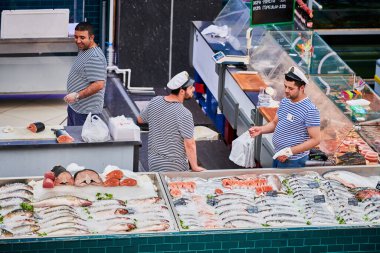 Voronezh, Rusya, 23.08.2019 - Yerel pazarda balık satıcıları. Üç adam balık ticaretini tartışıyor. Markette yeni yakalanmış çeşitli deniz ürünleri..