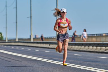 Voronezh, Rusya - 24.08.2019 - Genç kız yol boyunca koşar. Koşu maratonu ve şampiyonluk yarışması, fotokopi alanı. Sokak dışarı koşuyor. Sağlıklı spor etkinliği.