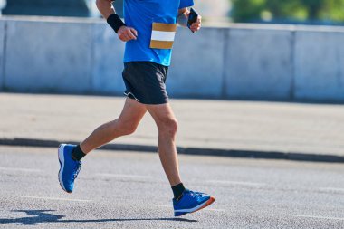 Koşan adam. Şehir yolunda spor kıyafetleriyle koşan atletik bir adam. Sağlıklı yaşam tarzı, spor hobisi. Sokak çalışması, açık hava koşusu.