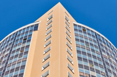 Çok katlı bir bina. Fotoğrafçılıkta ritim. Çok katlı cephe, pencereler ve apartman blokları, kapatın. Yüksek binadaki modern daireler. Bakış açısı.