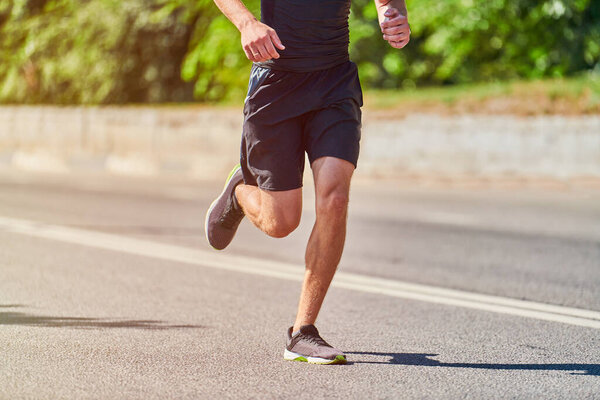 Running man. Athletic man jogging in sportswear on city road. Healthy lifestyle, fitness sport hobby. Street workout, sprinting outdoor