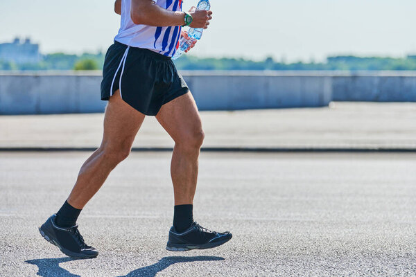 Running man. Athletic man jogging in sportswear on city road. Healthy lifestyle, fitness sport hobby. Street workout, sprinting outdoor
