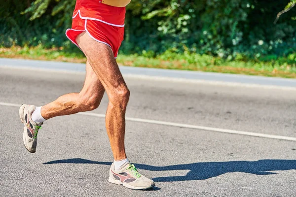 Running old man. Old man jogging in sportswear on city road. Healthy lifestyle, fitness sport hobby. Street workout, sprinting outdoor