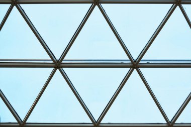 İş merkezinde saydam tavan. Cam üçgen pencereler. Ağ yapı mimarisi. Çerçevelenmiş camın soyut geometrik deseni