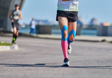 Koşan adam. Şehir yolunda spor kıyafetleriyle koşan atletik bir adam. Sağlıklı yaşam tarzı, spor hobisi. Sokak çalışması, açık hava koşusu.