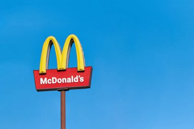 Moscow, 25.08.2019 - McDonalds roadside cafe logo, copy space. McDonald sign board, blue sky background. Drive thru fast food restaurant. Road outdoor advertising. clipart