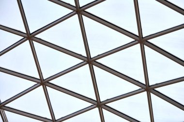 İş merkezinde saydam tavan. Cam üçgen pencereler. Ağ yapı mimarisi. Çerçevelenmiş camın soyut geometrik deseni