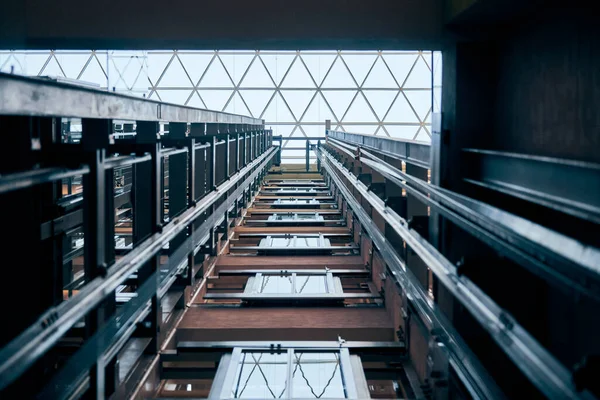 Open elevator lift shaft. Modern architecture with transparent ceiling. Shopping mall or business center. Maintenance repair and service