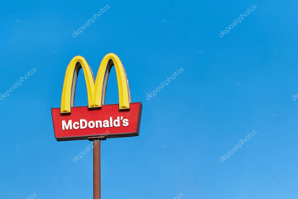 Moscow, 25.08.2019 - McDonalds roadside cafe logo, copy space. McDonald sign board, blue sky background. Drive thru fast food restaurant. Road outdoor advertising.