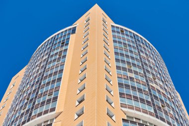 Çok katlı bir bina. Fotoğrafçılıkta ritim. Çok katlı cephe, pencereler ve apartman blokları, kapatın. Yüksek binadaki modern daireler. Bakış açısı.