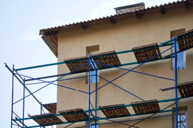 İnşaat alanındaki iskele. İskeleli eksik bina ve dekorasyon. Yeni apartman bloğunda çalışma devam ediyor