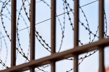 Hapishane çitlerinde dikenli teller. Yasak bölgeden kısıtlı erişim. Güvenlik görevlisi.