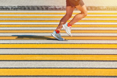 Yaya geçidinde koşan adam, kopyalama alanı. Şehir yolunda spor kıyafetleriyle koşan atletik bir adam. Sağlıklı yaşam tarzı, spor hobisi. Trafik ihlali. Sokak çalışması, açık hava koşusu.