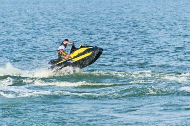 Su motosikletli adam. Yaz tatilinde tropikal denizlerdeki şahsi su araçlarında. Genç adam deniz yolculuğu hobisi. PWC spor etkinliği