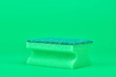 Temizlik, temizlik ve bulaşık yıkama için yeşil sünger. Yumuşak ve sert çift taraflı sünger. Asgari yeşil arkaplan, kopyalama alanı.