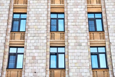 Çok katlı bir bina. Fotoğrafçılıkta ritim. Çok katlı cephe, pencereler ve apartman blokları, kapatın. Yüksek binadaki modern daireler. Bakış açısı.