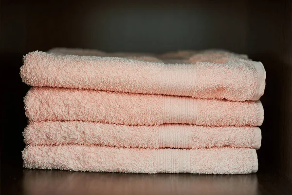 Towels stack. Dry bath towels in gym closet, close up. Soft and soft to the touch towels