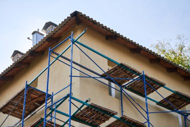 İnşaat alanındaki iskele. İskeleli eksik bina ve dekorasyon. Yeni apartman bloğunda çalışma devam ediyor